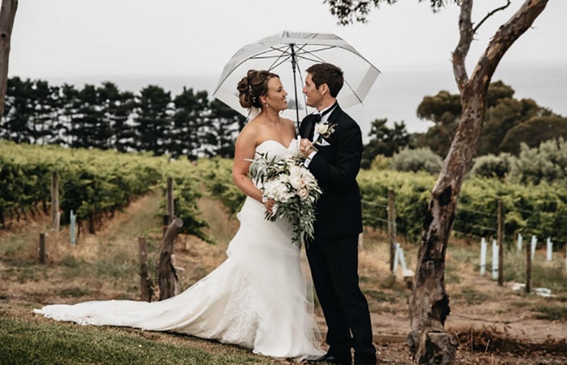 wedding couple posed under umbrella